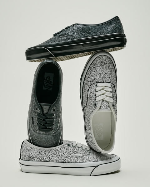 Three Vans shoes with a cracked texture, stacked on a white background