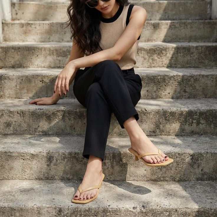Woman with long hair and sunglasses sitting on concrete steps