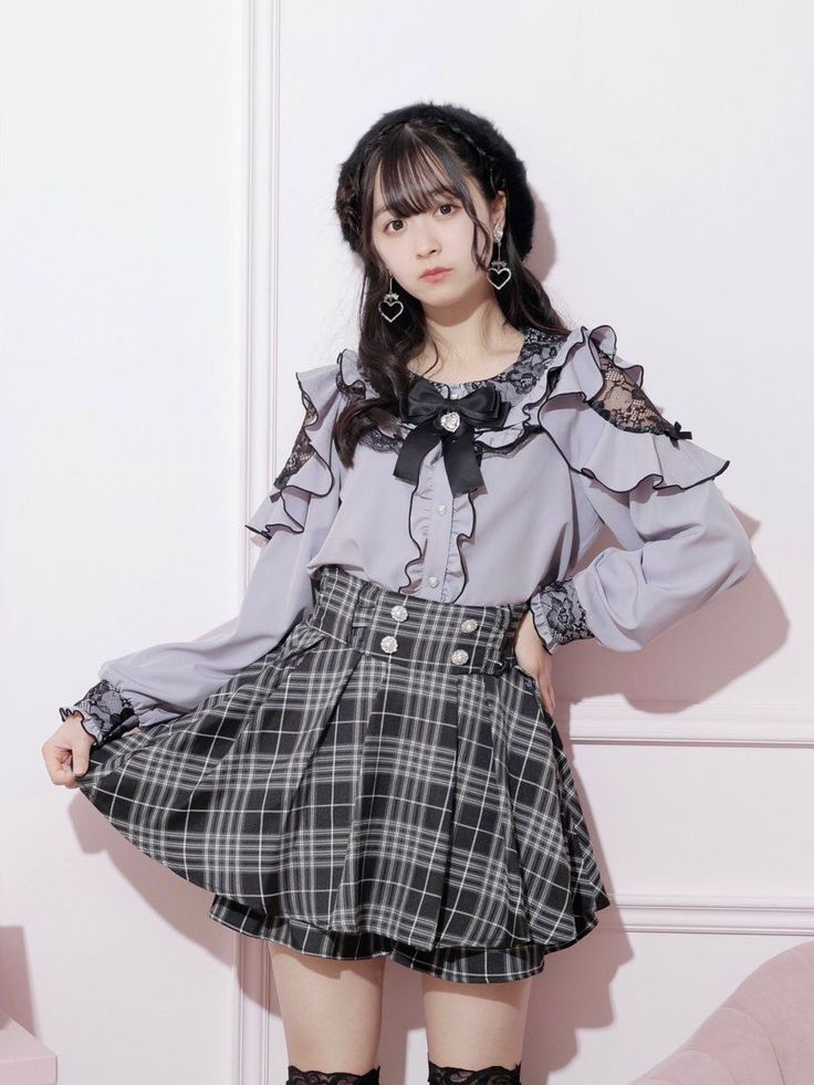 Woman in a plaid skirt and ruffled blouse with a black beret indoors