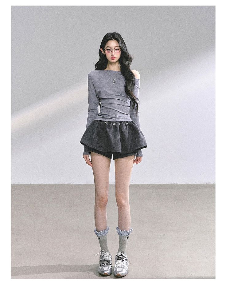 Woman with long hair wearing an off-shoulder top and mini skirt indoors