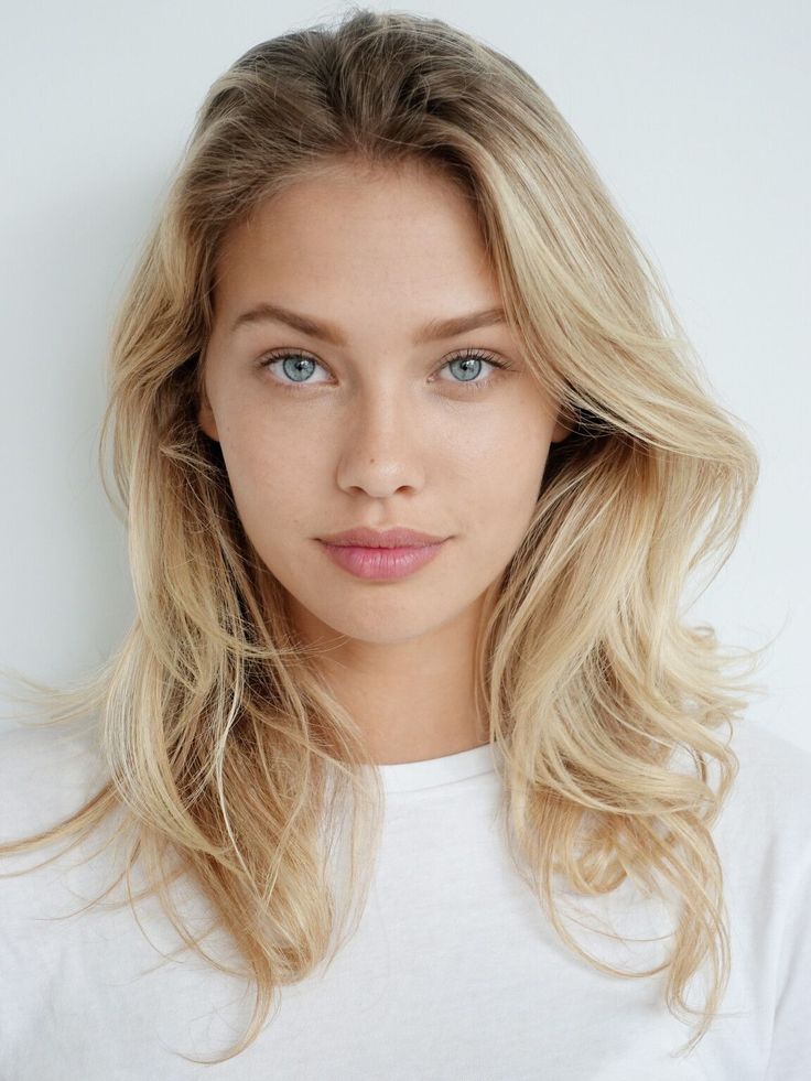 Woman with blonde hair and blue eyes wearing a white t-shirt