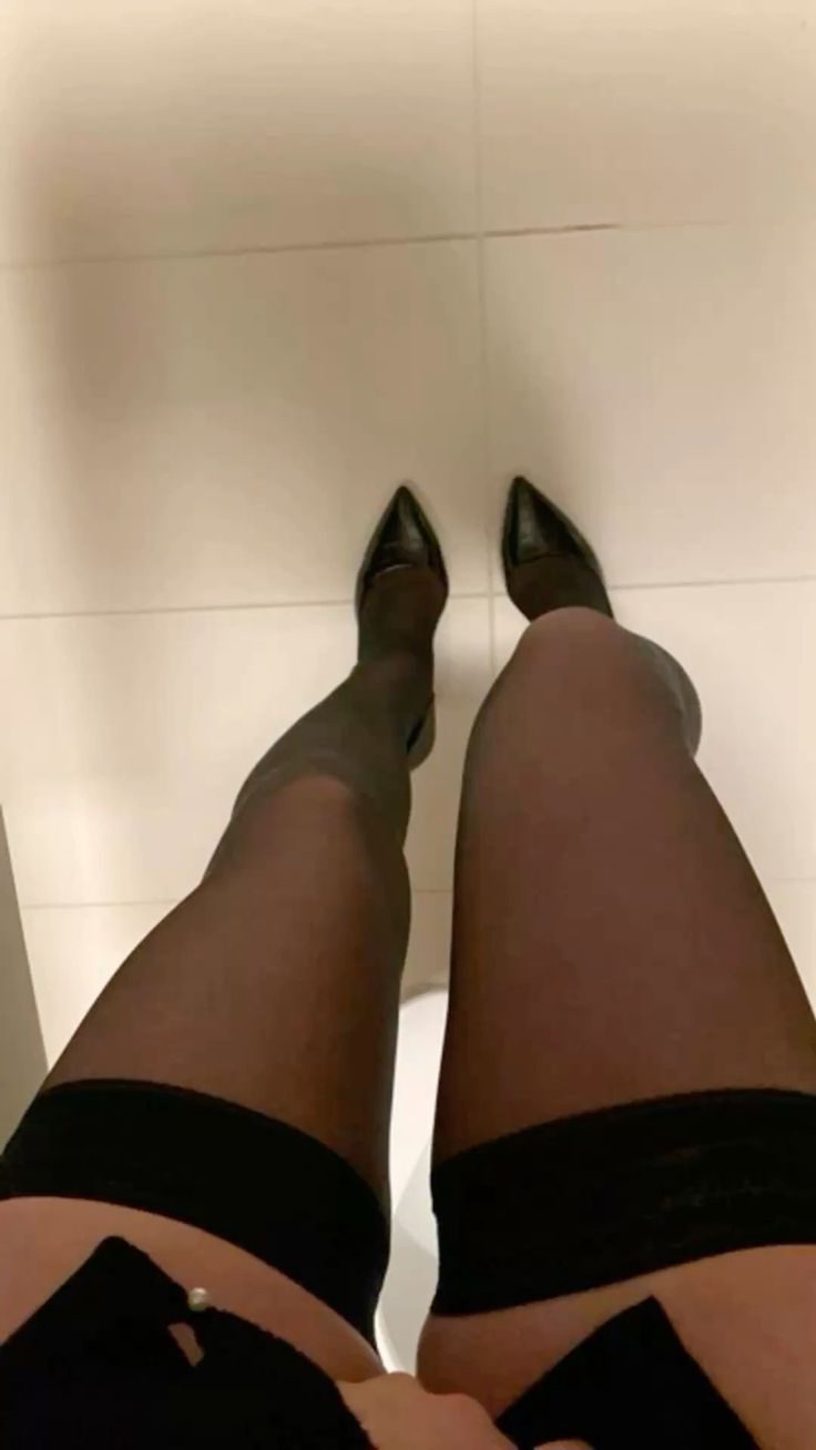 Person wearing black stockings and high heels from a low angle