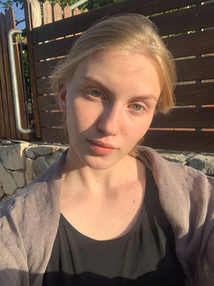 Young woman with blonde hair and green eyes in golden hour sunlight