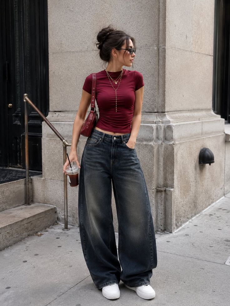 Woman in a red crop top and wide leg jeans on a city street