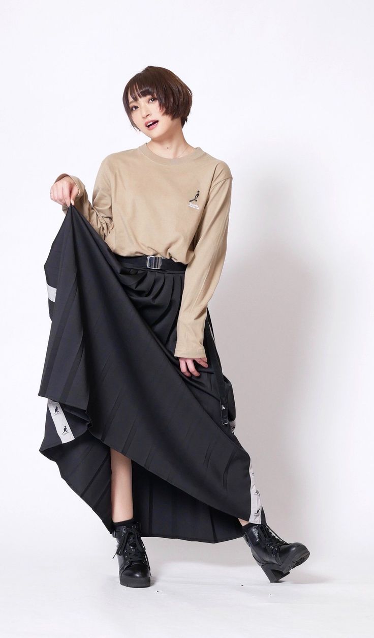 Woman with short hair in a long sleeve shirt and black skirt posing in a studio