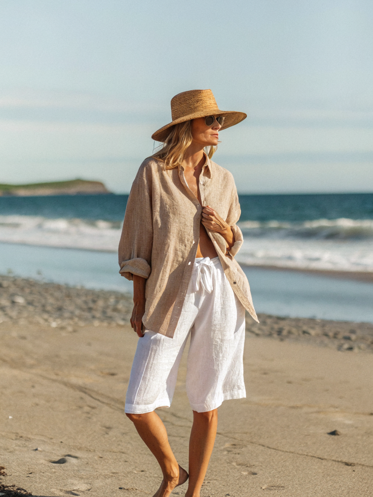 Woman in a straw hat and linen shirt on a beach