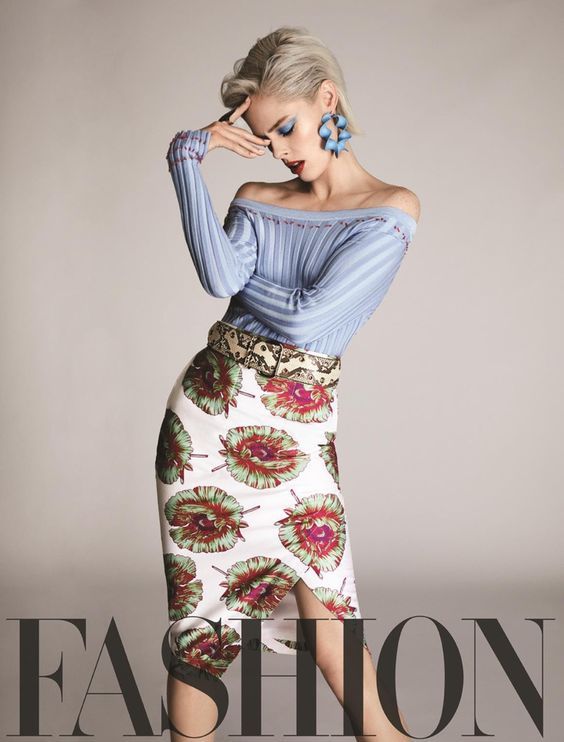Woman with short blonde hair in an off-shoulder top and floral skirt