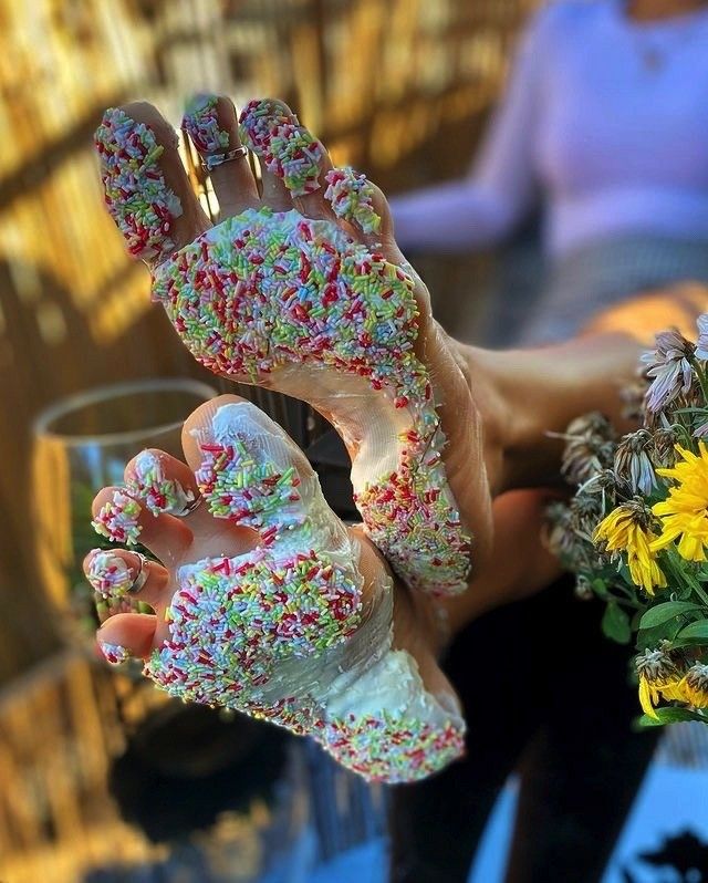 Feet covered in white frosting and colorful sprinkles