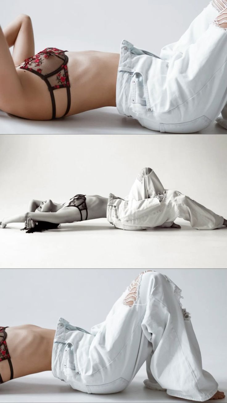 Woman in lingerie and ripped jeans lying on a white studio floor