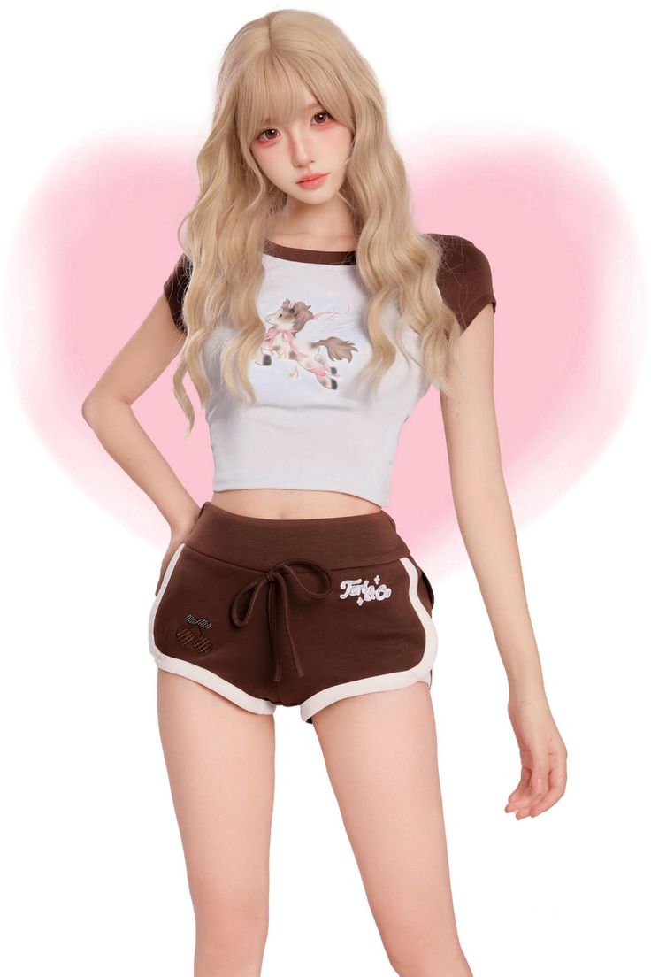 Woman with long blonde hair wearing a crop top and short shorts against a pink background
