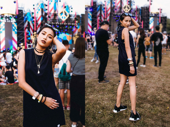 Woman in a black dress and sunglasses at an outdoor music festival