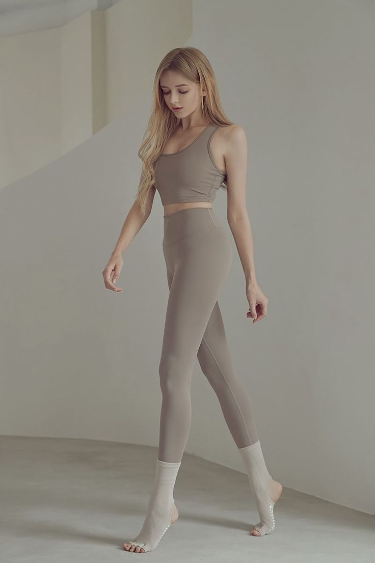 Woman with long blonde hair in a sports bra and leggings with yoga socks