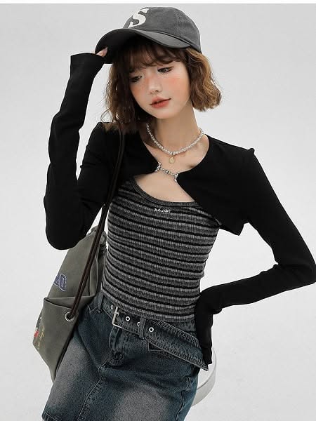 Woman in a baseball cap, black bolero, and denim skirt