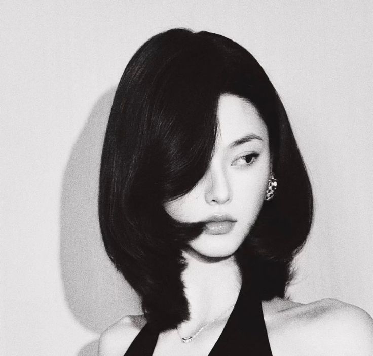Woman with short black hair and a black dress in a black and white portrait
