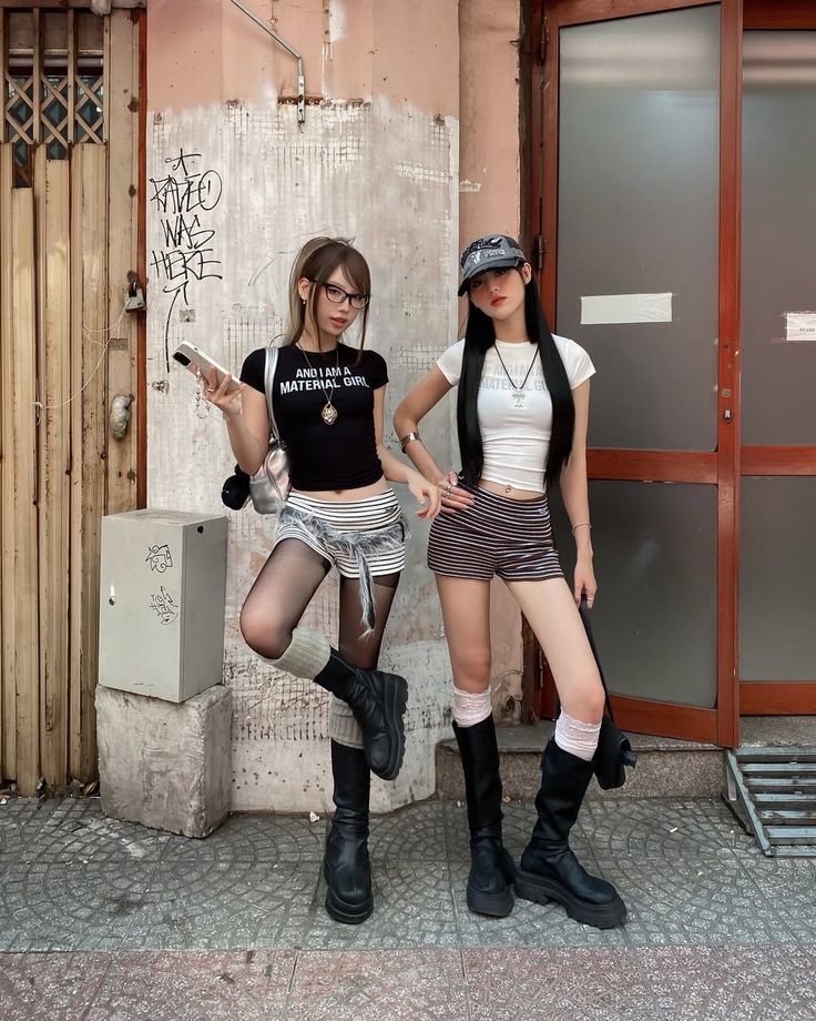 Two women in streetwear outfits posing on a city street