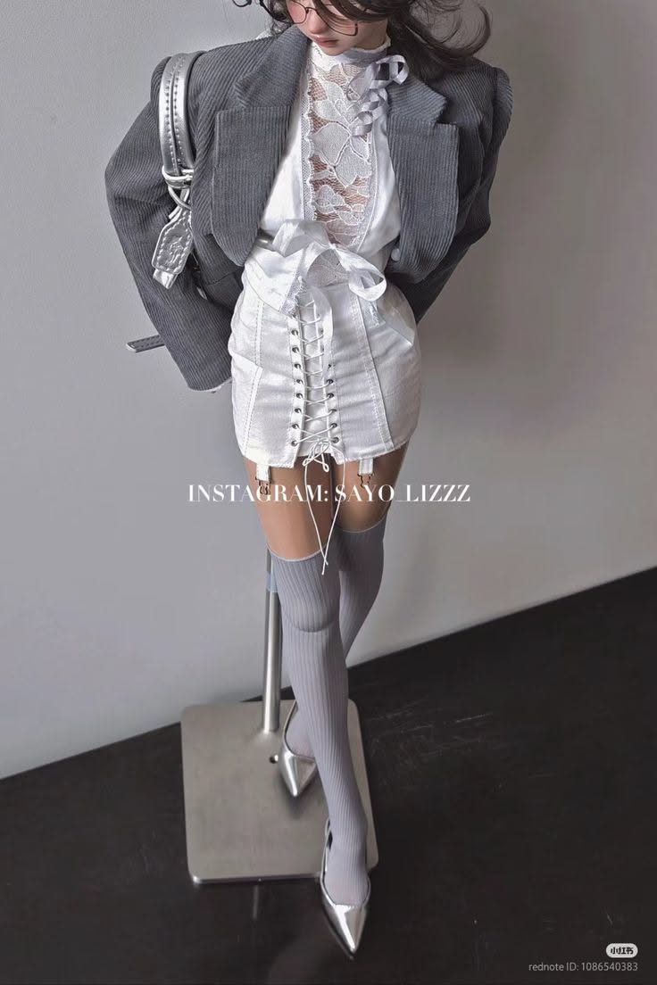 Woman in a corduroy jacket, lace top, corset skirt, and thigh-high socks