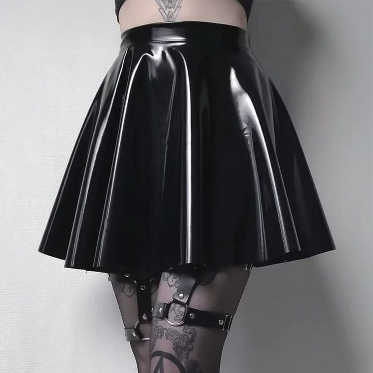 Person wearing a black latex skirt, garter belt, and thigh high stockings